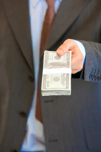 Homme d'affaires donnant pile de dollars. Gros plan . — Photo