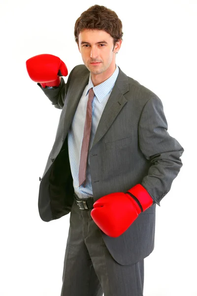 Серьезный современный бизнесмен в боксёрских перчатках размахивает оружием, чтобы напасть — стоковое фото