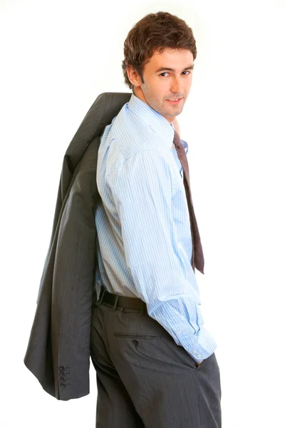 Улыбающийся бизнесмен с курткой на плече, оглядывающийся назад — стоковое фото