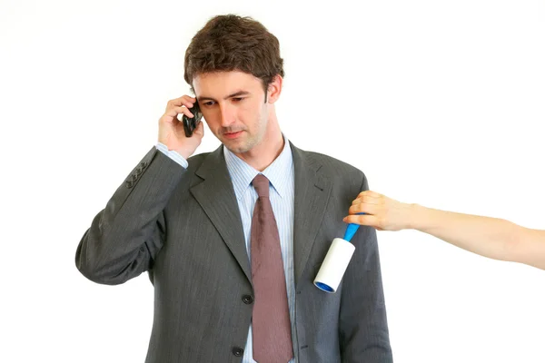 Secretary cleaning chiefs suit while he talking on phone — Stock Photo, Image