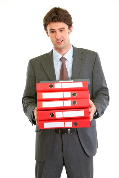 Displeased modern businessman holding many folders — Stock Photo, Image