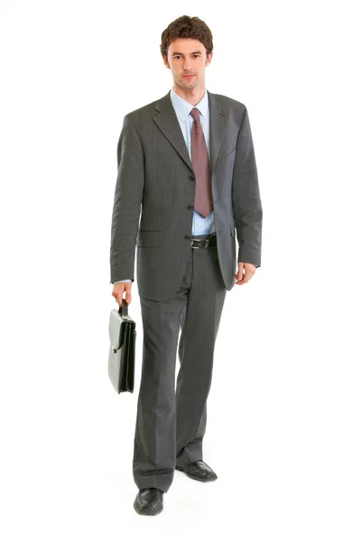 Fiducioso uomo d'affari moderno con valigia fare passo — Foto Stock
