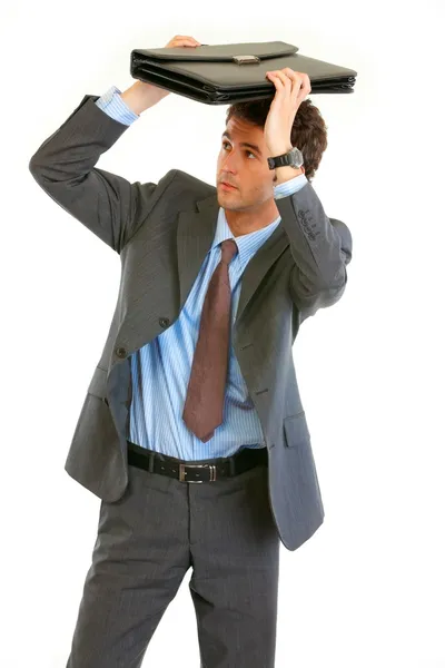 Scared young businessman holding briefcase over head — Stock Photo, Image