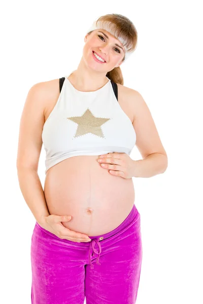 Χαμογελώντας όμορφη έγκυος γυναίκα σε αθλητικά ενδύματα, κρατώντας την κοιλιά — Φωτογραφία Αρχείου