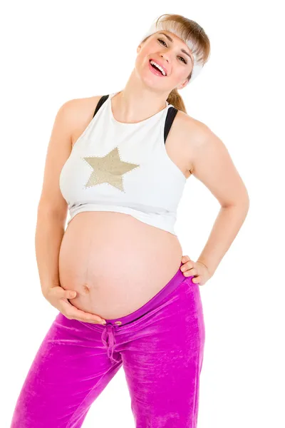 Счастливая красивая беременная женщина в спортивной одежде, держащая живот — стоковое фото