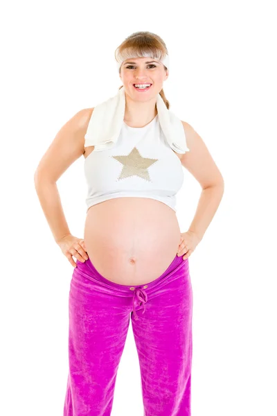 Улыбающаяся красивая беременная женщина в спортивной одежде держит полотенце — стоковое фото
