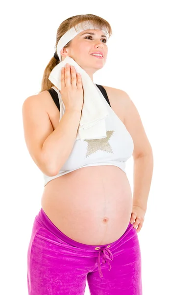 Sonriente hembra embarazada limpiándose la cara con toalla después de hacer ejercicio —  Fotos de Stock
