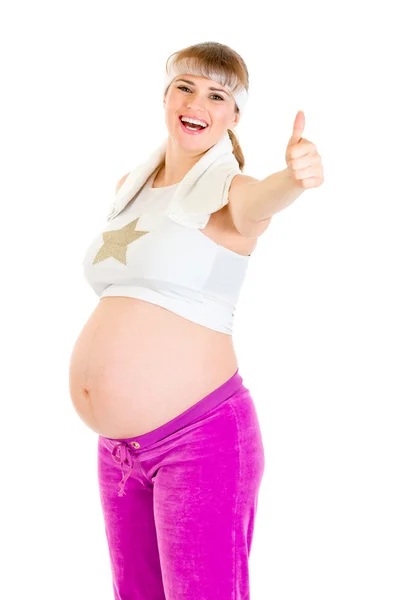 Sonriendo hermosa embarazada en ropa deportiva mostrando los pulgares hacia arriba gesto — Foto de Stock