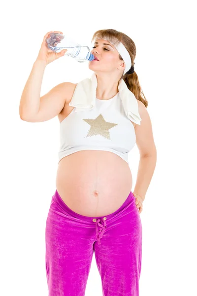 Беременная женщина пьет воду из бутылки после тренировки — стоковое фото