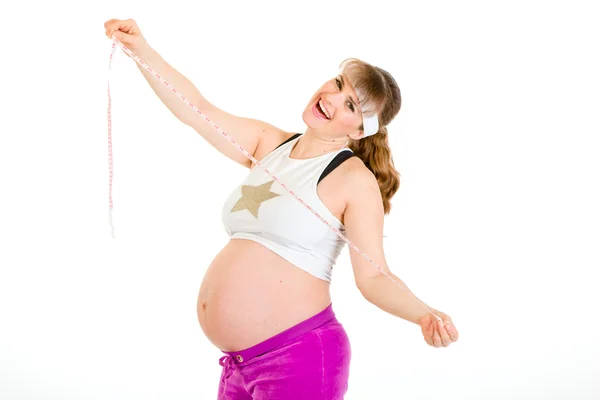 Задоволена красива вагітна жінка тримає мірну стрічку в руках — стокове фото