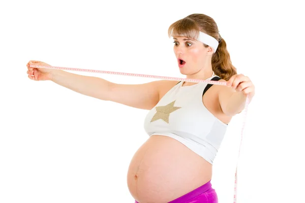 Förvånad vacker gravid kvinna tittar på mått band — Stockfoto