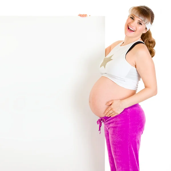 Sorridente bella donna incinta in possesso di cartellone bianco — Foto Stock