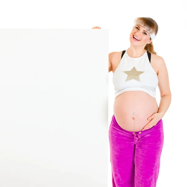 Feliz hermosa embarazada sosteniendo cartelera en blanco — Foto de Stock