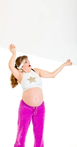Mujer embarazada hermosa sorprendida sosteniendo la cartelera en blanco sobre su cabeza —  Fotos de Stock
