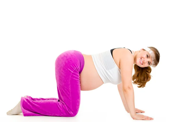 Улыбающаяся красивая беременная женщина делает упражнения — стоковое фото