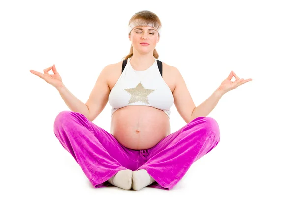 Bella donna incinta che fa esercizi di yoga sul pavimento — Foto Stock