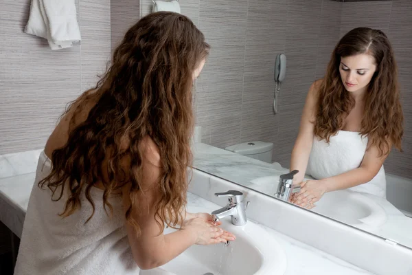 Mooie vrouw wassen hand in badkamer — Stockfoto