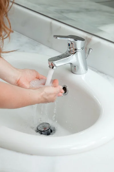 Mulher lavando as mãos no banheiro — Fotografia de Stock