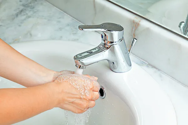 Femme se laver les mains dans la salle de bain — Photo