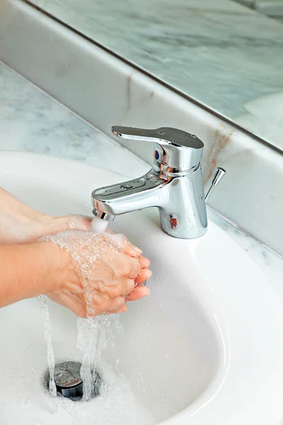 Mulher lavando as mãos no banheiro — Fotografia de Stock