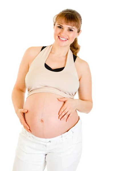 Gülümseyen güzel hamile kadının karnı üzerinde beyaz izole holding — Stok fotoğraf