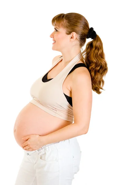 Sonriente hermosa embarazada sosteniendo su vientre aislado en blanco —  Fotos de Stock