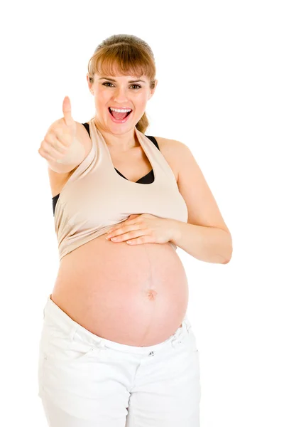 Mulher grávida feliz tocando sua barriga e mostrando polegares para cima gesto — Fotografia de Stock