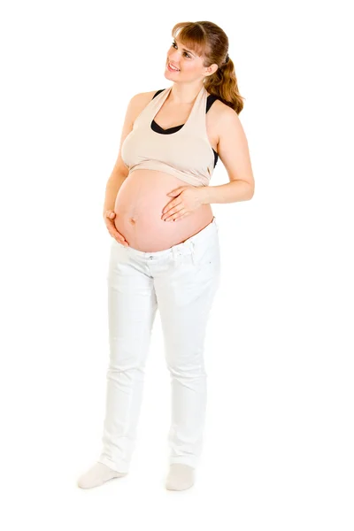 Dromen mooie zwangere vrouw houden haar buik geïsoleerd op wit — Stockfoto