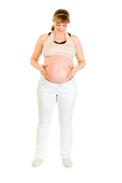 Piękna kobieta w ciąży trzymając jej brzuch na białym tle — Zdjęcie stockowe