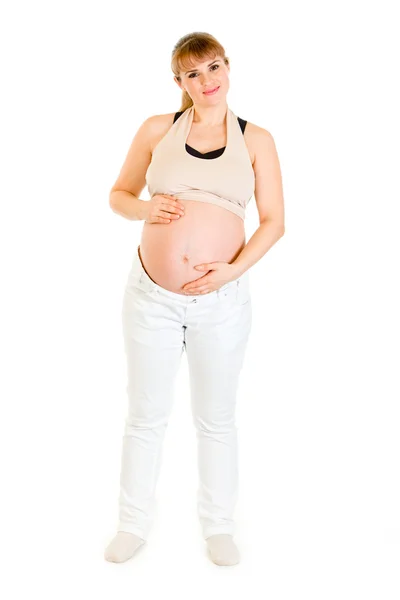 白で隔離される彼女の腹を保持している妊娠中の女性を魅力的な笑みを浮かべてください。 — ストック写真