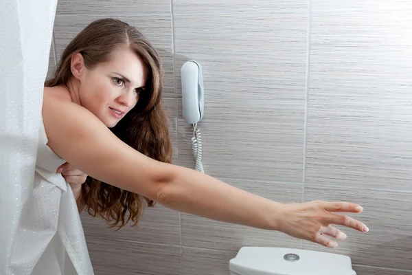 Mooie vrouw in badkamer streching voor iets — Stockfoto