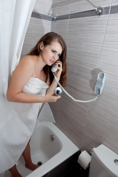 Aantrekkelijke vrouw maken oproep in badkamer — Stockfoto