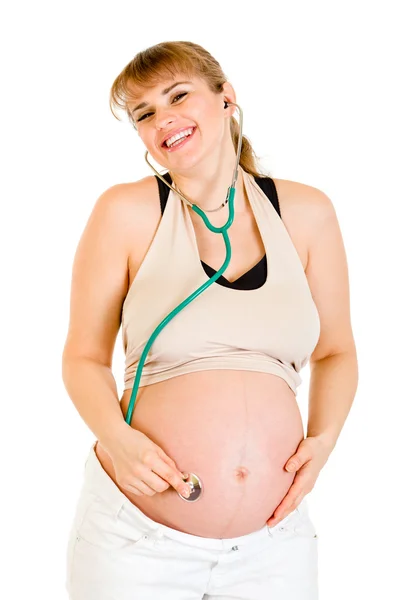 Mujer embarazada feliz sosteniendo estetascopio en su vientre — Foto de Stock