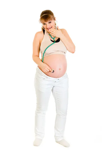 在她的肚子上拿听诊器的惊讶怀孕女性 — 图库照片