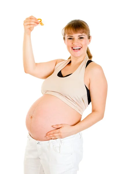 Mujer embarazada sonriente sosteniendo muñeco bebé — Foto de Stock
