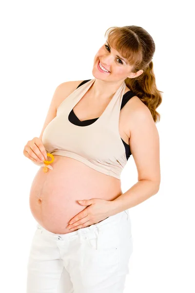 Lächelnde Schwangere mit Babyattrappe am Bauch — Stockfoto