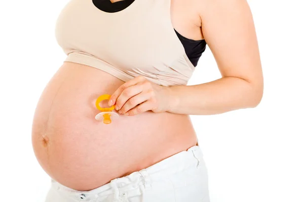 Беременная женщина держит манекен рядом с животом. Крупный план . — стоковое фото