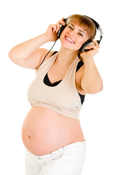 Gelukkig zwangere vrouw luisteren muziek in hoofdtelefoon — Stockfoto