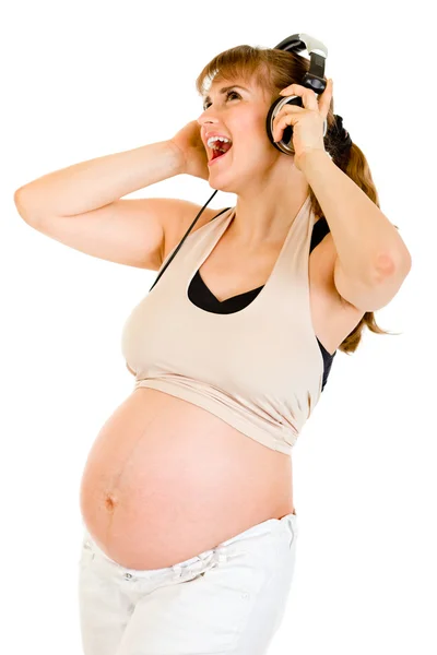 Mujer embarazada feliz escuchando música en auriculares — Foto de Stock