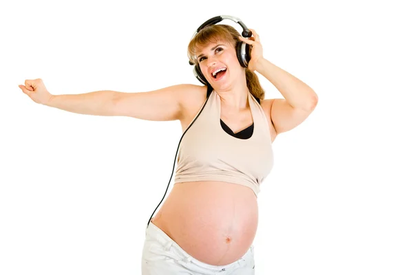 Happy pregnant woman listening music in headphones — Stock Photo, Image