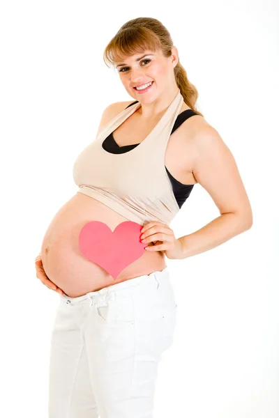 微笑着握着她的肚子里附近的心的怀孕妇女 — 图库照片