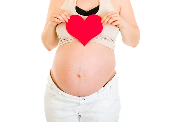 Έγκυος γυναίκα που κρατά την καρδιά χαρτί στα χέρια της. κινηματογράφηση σε πρώτο πλάνο. — Φωτογραφία Αρχείου