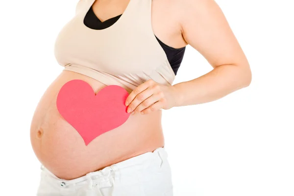 Mujer embarazada con el corazón en la barriga. Primer plano . — Foto de Stock