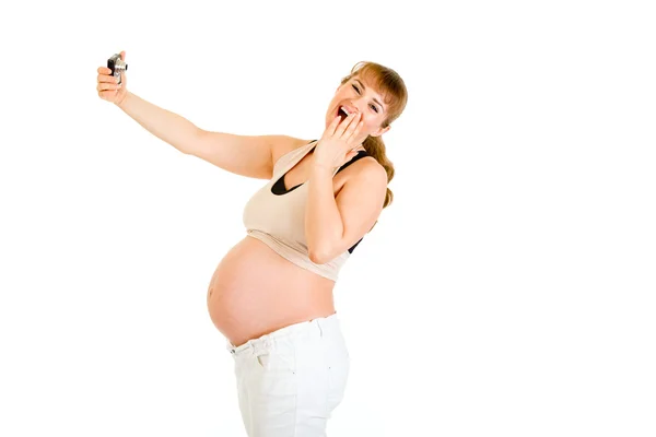 Laughing pregnant woman photographing herself — Stok fotoğraf