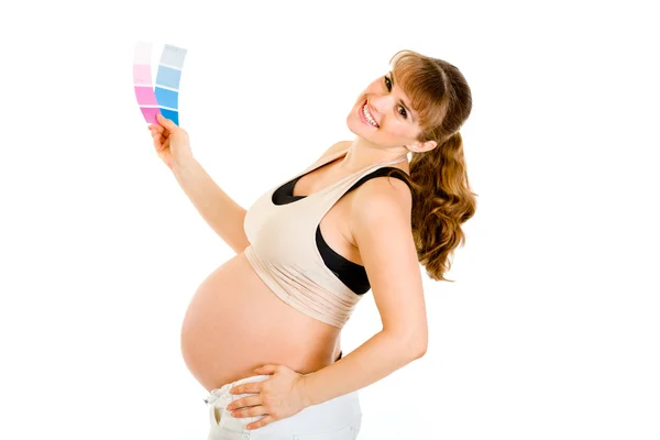 Feliz mulher grávida segurando amostras de tinta de cor — Fotografia de Stock