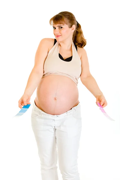 Confuso donna incinta in possesso di campioni di vernice a colori — Foto Stock
