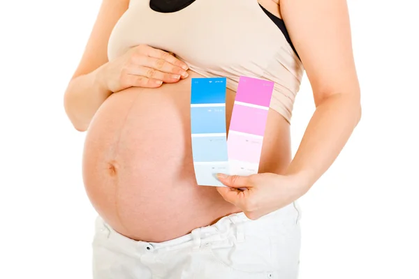 Mulher grávida segurando amostras de tinta a cores. Close-up . — Fotografia de Stock