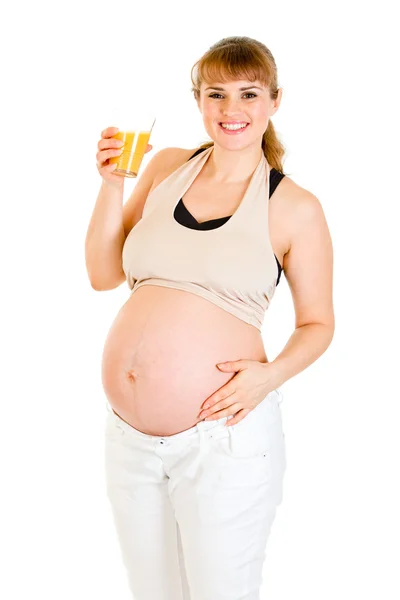 Usmívající se těhotná žena v ruce držel sklenici šťávy — Stock fotografie