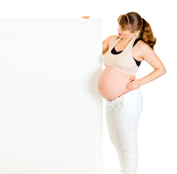 惊讶漂亮的孕妇持空白广告牌 — 图库照片
