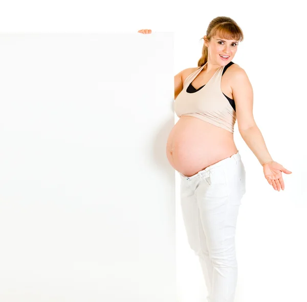 Überrascht charmante schwangere Frau mit leerer Plakatwand — Stockfoto